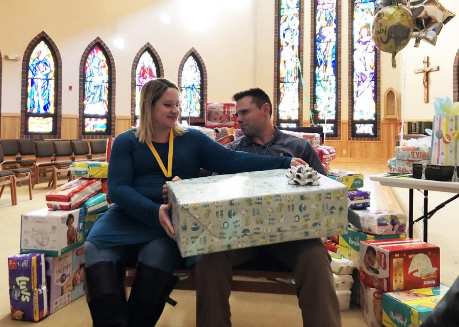 Katrina and Matt Galli prepare to open gifts at their baby shower.
