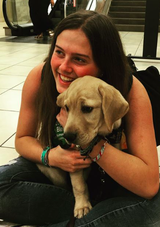 Mikaela Lang cuddles with Ode, her service-dog-in-training, upon her return to the United States from a year-long foreign exchange program in Luján, Argentina.