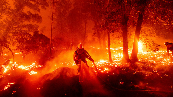 A firefighter battles the Creek Fire as it threatens homes in the Cascadel Woods neighborhood of Madera County, Calif., on Monday, Sept. 7, 2020. (AP Photo/Noah Berger)
