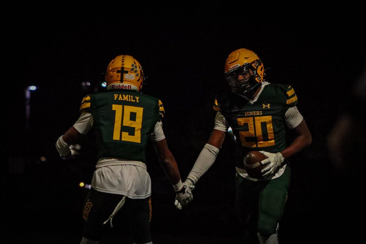 Demari Stacker and Pele Masina high fiving after Masina scores a touchdown.